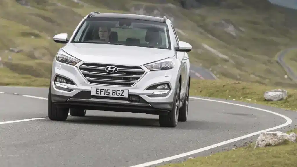 Los 12 mejores coches de segunda mano por menos de 10.000 euros 8 Hyundai Tucson 1.7 CRDi de color plateado conducido por un hombre en una carretera montañosa