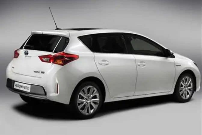 Los 16 mejores coches de segunda mano para comprar en 2026 7 Toyota Auris Hybrid blanco visto de perfil trasero sobre fondo gris de estudio