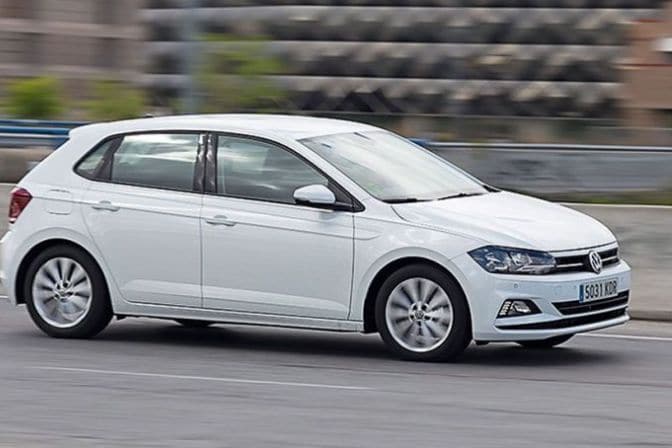 Los 16 mejores coches de segunda mano para comprar en 2026 2 Volkswagen Polo blanco de sexta generación circulando por una carretera urbana a velocidad