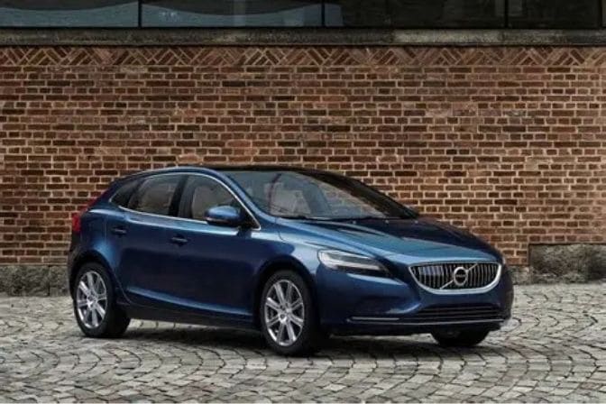 Los 16 mejores coches de segunda mano para comprar en 2026 16 Volvo V40 azul aparcado sobre suelo adoquinado frente a una pared de ladrillo