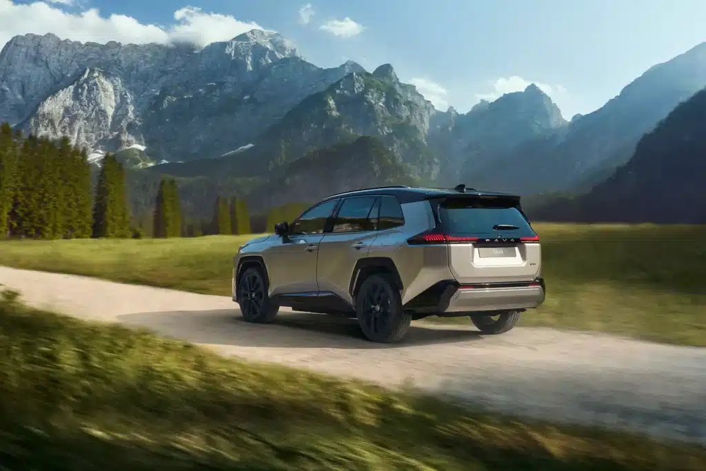 Los 8 SUV más fiables en 2026. Cuál deberías comprar 1 Toyota RAV4 transitando a velocidad por calle de tierra en un paisaje natural.