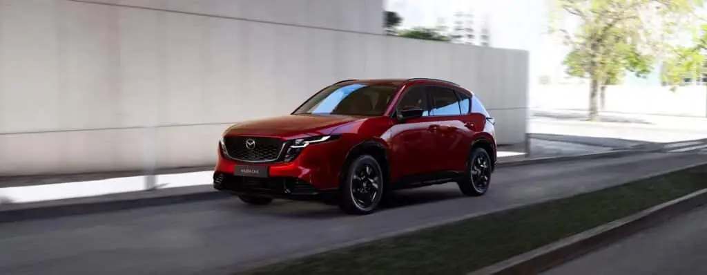 Los 8 SUV más fiables en 2026. Cuál deberías comprar 2 Mazda CX5 de color rojo circulando por espacio urbano.