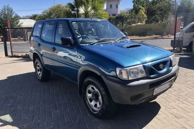 Los mejores 4x4 baratos para comprar a un particular en 2026 1 Nissan Terrano II 2.7 TDi manual de color azul, visto de frente y en ángulo lateral, aparcado en un entorno residencial