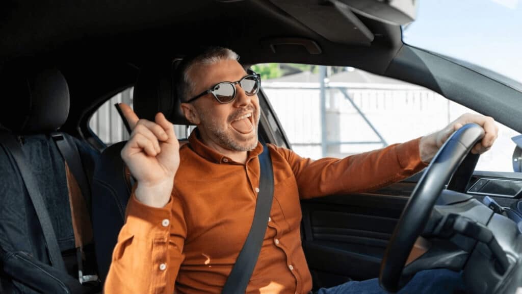 Hombre conduciendo su coche con tranquilidad tras una revisión previa antes de la compra