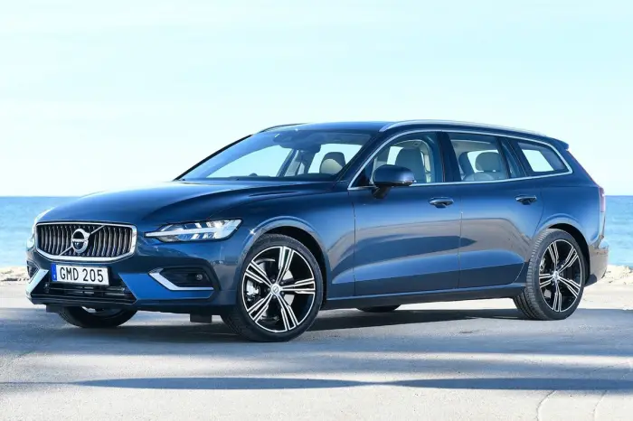 Los 12 mejores coches familiares de segunda mano para 2026 7 Volvo V60 azul oscuro parado en una carretera junto al mar