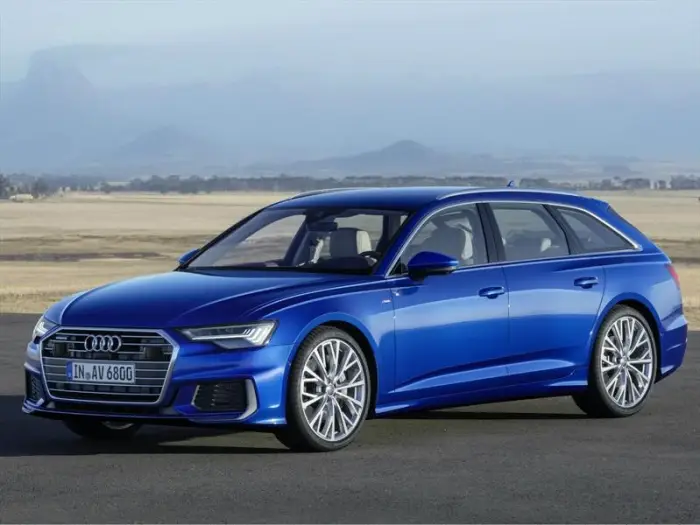 Los 12 mejores coches familiares de segunda mano para 2026 9 Audi A6 Avant azul en una carretera recta con montañas brumosas al fondo