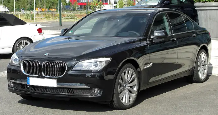 Los 12 mejores BMW de segunda mano para comprar en 2026 6 BMW Serie 7 F01 negro aparcado al sol con los faros encendidos