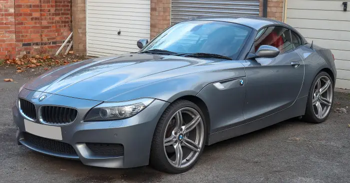 Los 12 mejores BMW de segunda mano para comprar en 2026 11 BMW Z4 E89 gris azulado con el techo duro cerrado, frente a un garaje