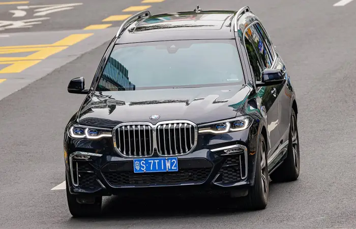 Los 24 mejores coches familiares de 7 plazas de ocasión 20 BMW X7 G07 negro circulando por una calzada con marcas viales amarillas, fotografiado desde arriba y de frente