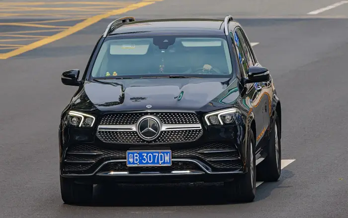 Los 24 mejores coches familiares de 7 plazas de ocasión 21 Mercedes GLE V167 negro circulando de frente por una avenida, con la parrilla de estrellas y el capó brillante