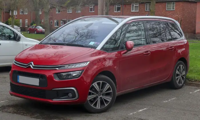 Los 21 mejores monovolúmenes de segunda mano para 2026 9 Citroën Grand C4 SpaceTourer rojo con techo blanco, de tres cuartos delantero ante casas de ladrillo