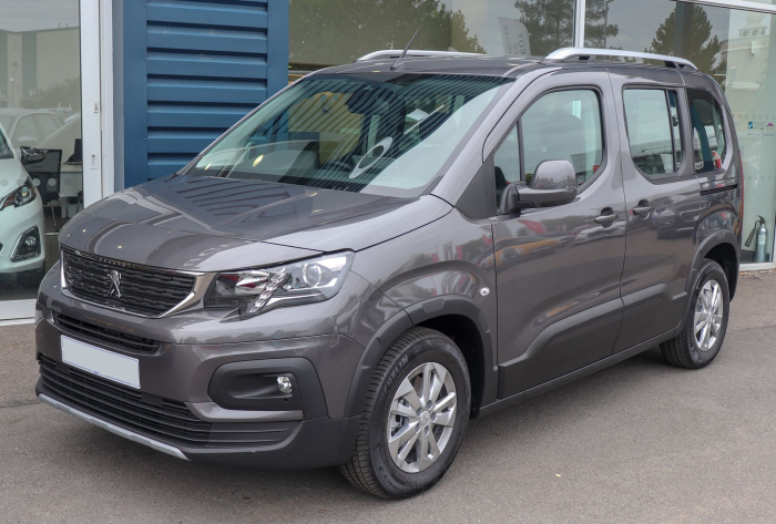 Los 21 mejores monovolúmenes de segunda mano para 2026 16 Peugeot Rifter gris de tres cuartos delantero, con la puerta corredera a la vista, en un concesionario