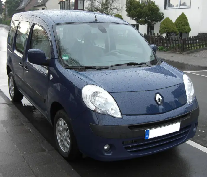 Los 21 mejores monovolúmenes de segunda mano para 2026 19 Renault Kangoo Combi azul mojado por la lluvia, de tres cuartos delantero en una calle residencial