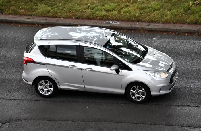 Los 21 mejores monovolúmenes de segunda mano para 2026 7 Ford B-Max plateado visto desde arriba en tres cuartos delantero, junto a una acera con césped